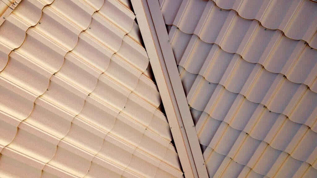 House roof surface covered with brown metal tile sheets, beige and white metal roofing material, roof repair in Boston
