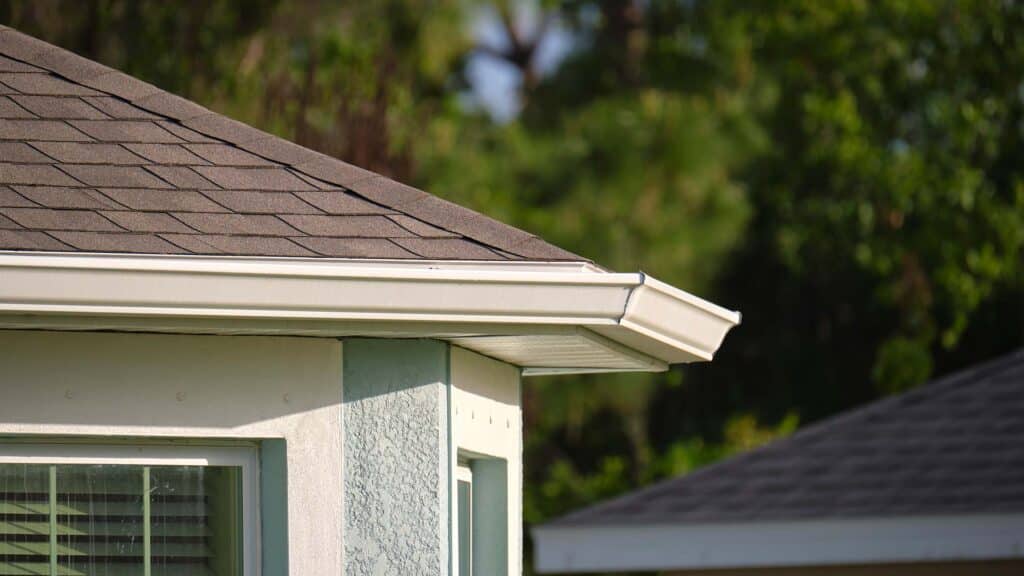 Close-up detail of cottage house gutter with metal planks, roof with gutter rain system, gutter cleaning, clean gutters