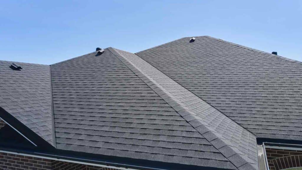 Aerial view of a residential roof with asphalt shingles, showcasing proper roof ventilation and modern roofing materials