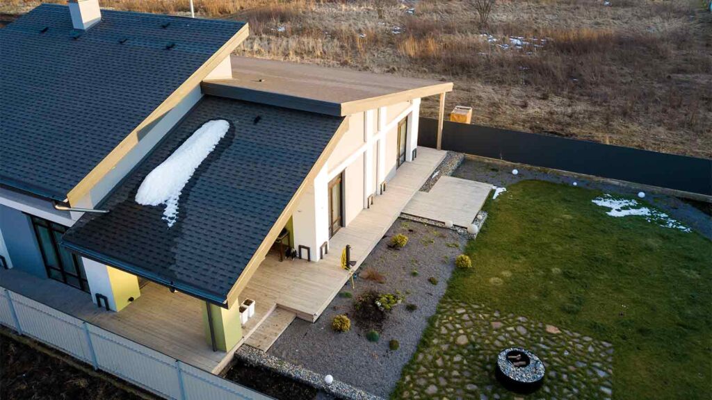Aerial top view of new residential house cottage and terrace with shingle roof after winter, spring roof inspection