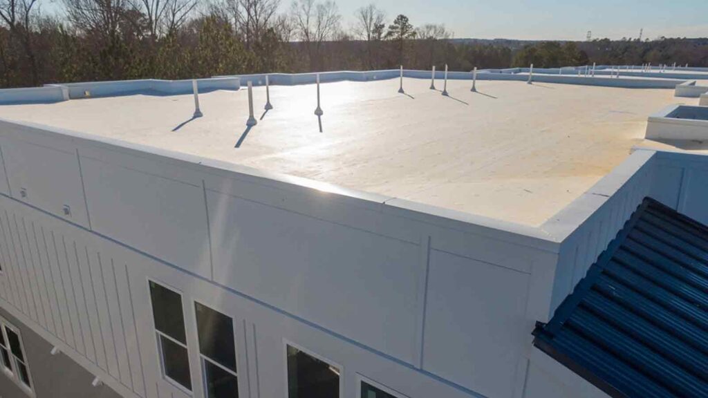Drone view of a TPO flat roof on a modern apartment building, highlighting durable roofing materials.