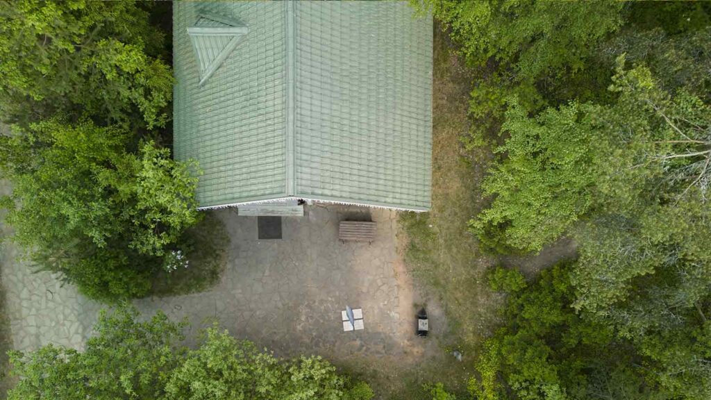 Aerial view of a house surrounded by lush greenery, ideal perspective for a roof inspection.